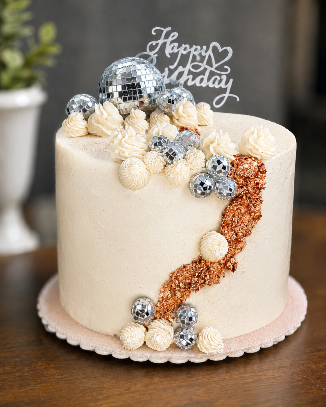 A custom celebration cake decorated with piped frosting and disco ball accents for a birthday celebration